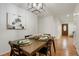 Charming dining area with a wooden table set for a meal, adjacent to a hallway and a door at 2840 S Yates St, Denver, CO 80236