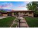 Charming brick home with a well-manicured lawn, updated siding, and cozy front porch seating at 2840 S Yates St, Denver, CO 80236