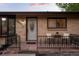 Close-up of the front porch featuring bistro seating and a decorative front door with sidelights at 2840 S Yates St, Denver, CO 80236