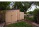 Outdoor storage shed in backyard with mature trees and a flower garden at 2840 S Yates St, Denver, CO 80236