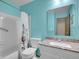 Bright bathroom featuring a granite vanity top, a white sink, and a shower with a floral shower curtain at 2627 E Nichols Cir, Centennial, CO 80122