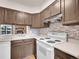 Efficient kitchen boasts abundant cabinet space, modern backsplash, and stainless vent hood at 2627 E Nichols Cir, Centennial, CO 80122