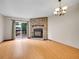 Bright living room with fireplace, sliding door to deck, and lovely chandelier at 2627 E Nichols Cir, Centennial, CO 80122