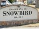 The Snowbird Phase I community sign featuring stone accents and manicured grounds at 390 Zang St # 5-102, Lakewood, CO 80228
