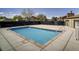 Community pool with a concrete deck, metal fence and lounge chairs at 390 Zang St # 5-102, Lakewood, CO 80228