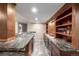 Basement bar features wood cabinetry, marble countertop, and wine refrigerator at 8696 W Iliff Ave, Lakewood, CO 80227