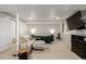 Finished basement with a comfortable seating area, bedroom space, and ample lighting at 8696 W Iliff Ave, Lakewood, CO 80227