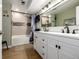 Bathroom featuring double sinks, a tub with shower, and modern fixtures at 8696 W Iliff Ave, Lakewood, CO 80227