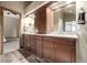 Bathroom with double vanity, dark wood cabinets, and large mirrors, providing ample space at 8696 W Iliff Ave, Lakewood, CO 80227