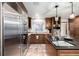 Gourmet kitchen featuring granite countertops, stainless steel refrigerator, and designer cabinetry at 8696 W Iliff Ave, Lakewood, CO 80227