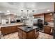 Spacious kitchen featuring a large center island with seating, stainless appliances, and ample cabinet space at 8696 W Iliff Ave, Lakewood, CO 80227
