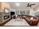 A grand living room featuring a stone fireplace, a large leather sofa, and an abundance of natural light at 8696 W Iliff Ave, Lakewood, CO 80227