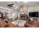 Cozy living room with vaulted ceilings, stone fireplace and a large leather sectional sofa at 8696 W Iliff Ave, Lakewood, CO 80227