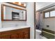 Well-lit bathroom features a vanity with wood cabinets and a framed mirror reflecting a glimpse into the room at 2381 Newark St, Aurora, CO 80010
