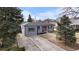 Attractive single-story home with an orange front door and mature trees in the front yard at 2381 Newark St, Aurora, CO 80010
