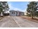 Charming single-story home boasts a well-maintained lawn, long driveway, and welcoming orange front door at 2381 Newark St, Aurora, CO 80010