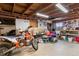 Garage featuring exposed wood beams, a workbench, and ample storage space at 2381 Newark St, Aurora, CO 80010