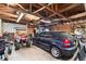 Garage featuring exposed wood beams and an automobile and four-wheeler parked inside at 2381 Newark St, Aurora, CO 80010