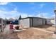Detached two-car garage with a gray exterior situated in a spacious backyard with a fire pit at 2381 Newark St, Aurora, CO 80010