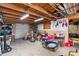 Spacious garage featuring exposed wood beams, a workbench, and ample storage space at 2381 Newark St, Aurora, CO 80010