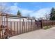 View of a three car garage with steel grate security fence around the back of the property at 2381 Newark St, Aurora, CO 80010