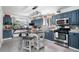Bright kitchen featuring blue cabinets, stainless steel appliances, and a large kitchen island at 2381 Newark St, Aurora, CO 80010