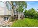 Well-maintained backyard features lush green grass, a deck, and mature trees, providing a serene outdoor space at 1752 Peninsula Cir, Castle Rock, CO 80104