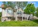 Landscaped backyard with a deck, mature trees, green lawn and partial brick exterior at 1752 Peninsula Cir, Castle Rock, CO 80104