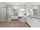Elegant bathroom with a soaking tub, dual vanities, granite countertops, and a glass-enclosed shower at 1752 Peninsula Cir, Castle Rock, CO 80104
