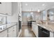 Bright kitchen featuring white cabinets, granite countertops, stainless steel sink, and modern appliances at 1752 Peninsula Cir, Castle Rock, CO 80104