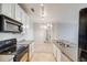 The kitchen features white cabinets, modern appliances, and a view to the dining area at 2672 S Cathay Way # 304, Aurora, CO 80013