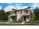 Modern two-story townhome with a mix of siding, stone accents, and professionally landscaped front yard at 17105 E Alameda Pkwy, Aurora, CO 80017