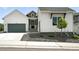 Charming home featuring white siding, a gray garage door, and well-maintained landscaping at 4855 Saddle Iron Rd, Castle Rock, CO 80104