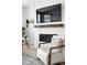 Modern living room with a cozy armchair, textured wall, and sleek fireplace at 4855 Saddle Iron Rd, Castle Rock, CO 80104