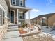 A lovely covered front porch with stone details, a beautiful front yard, and a dark entryway at 2924 Echo Park Dr, Castle Rock, CO 80104