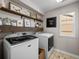 Bright laundry room featuring modern appliances, floating shelves, and stylish decor at 2924 Echo Park Dr, Castle Rock, CO 80104