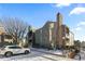 Multi-story condo building with stone chimney accents and exterior balcony, surrounded by trees at 14100 E Temple Dr # W04, Aurora, CO 80015