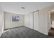 Neutral bedroom features a window, plush carpet, and a closet with sliding doors at 4292 E 91St Dr, Thornton, CO 80229