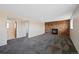 Large carpeted living room with brick fireplace and open access to a bathroom at 4292 E 91St Dr, Thornton, CO 80229