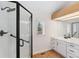 Bright bathroom features a shower with black trim, modern fixtures, and vanity with white cabinets at 1904 S Union Pl, Lakewood, CO 80228