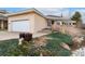 Tan exterior and well-manicured front garden with a two-car garage and a welcoming entryway at 1904 S Union Pl, Lakewood, CO 80228