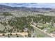 An aerial view of the property nestled among mature trees with other houses in the distance at 3640 Summertime Ct, Monument, CO 80132