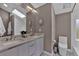 Modern bathroom featuring double sinks, a large mirror, and ample natural light from the skylight at 3640 Summertime Ct, Monument, CO 80132