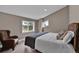 Warm bedroom featuring a corner reading chair and bright window with wooded scenery outside at 3640 Summertime Ct, Monument, CO 80132