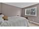 Neutral bedroom featuring a plush bed and bright window with wooded scenery outside at 3640 Summertime Ct, Monument, CO 80132