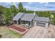 Charming gray home boasts a well-maintained lawn, cozy deck, and attached two-car garage at 3640 Summertime Ct, Monument, CO 80132