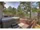 Backyard scene featuring a partially covered hot tub, trees, and wood fencing at 3640 Summertime Ct, Monument, CO 80132