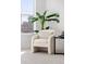 Close up of an armchair by a window with a round side table and a beautiful indoor plant at 1735 E 18Th Ave, Denver, CO 80218