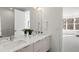 Bright bathroom with double sinks, modern fixtures, and a view to another bedroom at 1735 E 18Th Ave, Denver, CO 80218
