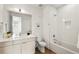 Well-lit bathroom featuring a modern vanity with storage and tub with tiled wall at 1735 E 18Th Ave, Denver, CO 80218